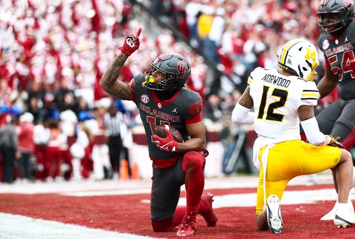 Nov 22, 2025; Norman, Oklahoma, USA;  Oklahoma Sooners wide receiver Javonnie Gibson (11) reacts in fron tof Missouri Tigers defensive back Dreyden Norwood (12) after scoring a touchdown during the second quarter at Gaylord Family-Oklahoma Memorial Stadium. Mandatory Credit: Kevin Jairaj-Imagn Images