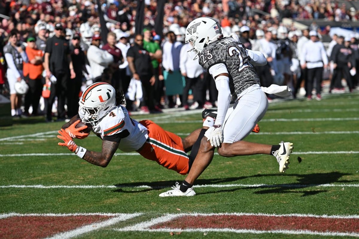 Nov 22, 2025; Blacksburg, Virginia, USA; Miami (FL) Hurricanes running back Mark Fletcher Jr. (4) dives into the end zone after a catch as Virginia Tech Hokies cornerback Thomas Williams (23) defends during the second quarter at Lane Stadium. Mandatory Credit: Brian Bishop-Imagn Images