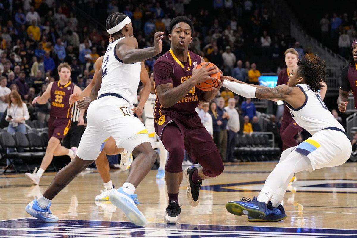Nov 22, 2025; Milwaukee, Wisconsin, USA;  Central Michigan Chippewas forward Rodney Johnson Jr. (24) drives for the basket between Marquette Golden Eagles guard Chase Ross (2) and guard Nigel James Jr. (0) during the first half at Fiserv Forum. Mandatory Credit: Jeff Hanisch-Imagn Images