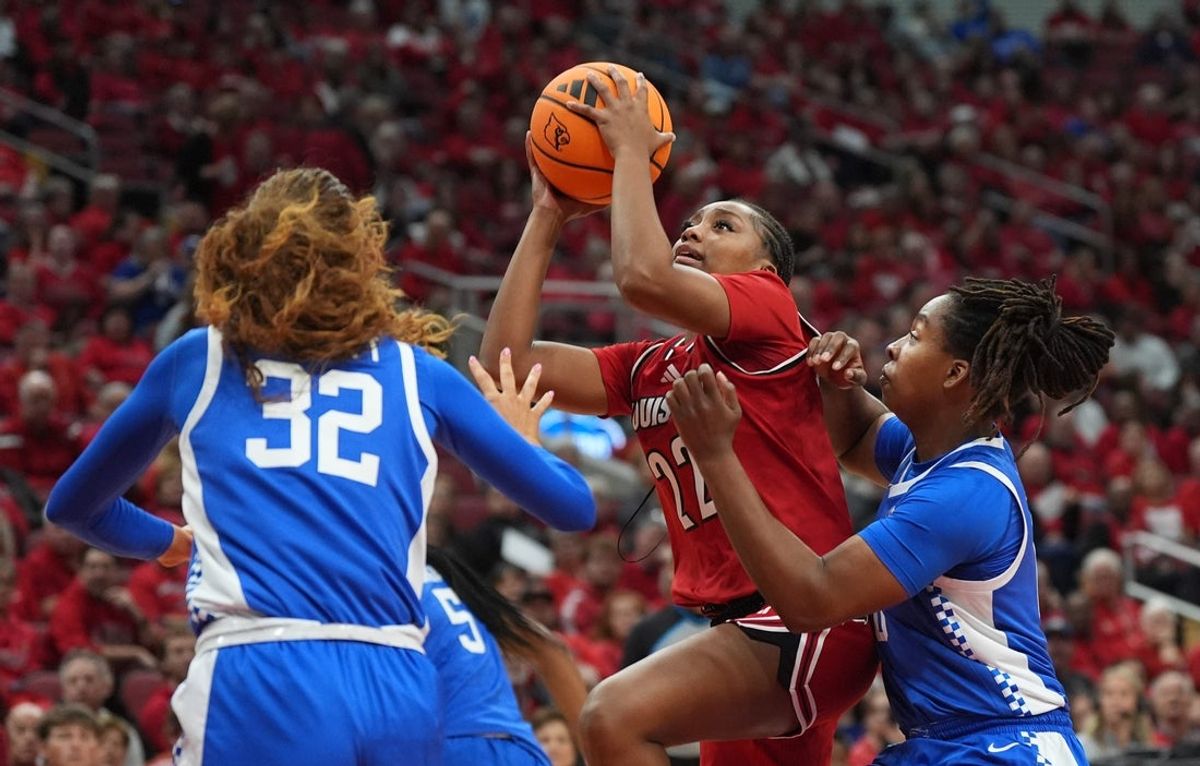 Louisville's guard Tajianna Roberts (22) makes the basket against Kentucky's forward Amelia Hassett (32) and guard Jordan Obi (0) in the KFC Yum! Center. 
November 22, 2025
