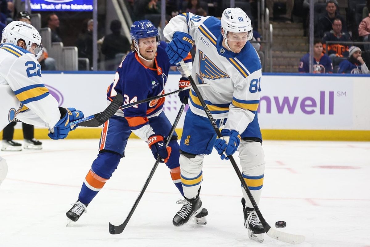 Nov 22, 2025; Elmont, New York, USA;  New York Islanders defenseman Adam Boqvist (34) and St. Louis Blues left wing Dylan Holloway (81) battle for control of the puck in the first period at UBS Arena. Mandatory Credit: Wendell Cruz-Imagn Images