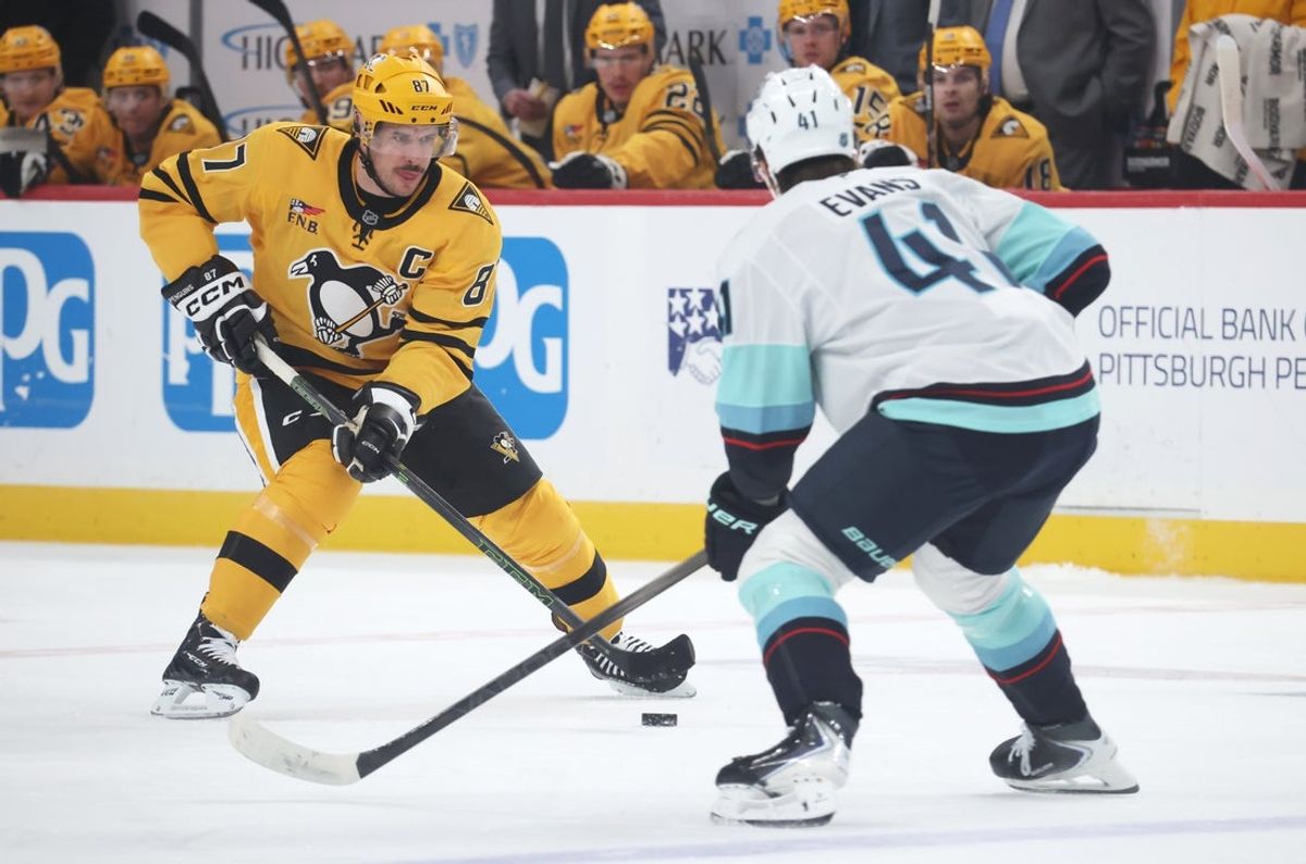 Nov 22, 2025; Pittsburgh, Pennsylvania, USA;  Pittsburgh Penguins center Sidney Crosby (87) skates with the puck against Seattle Kraken defenseman Ryker Evans (41) during the first period at PPG Paints Arena. Mandatory Credit: Charles LeClaire-Imagn Images