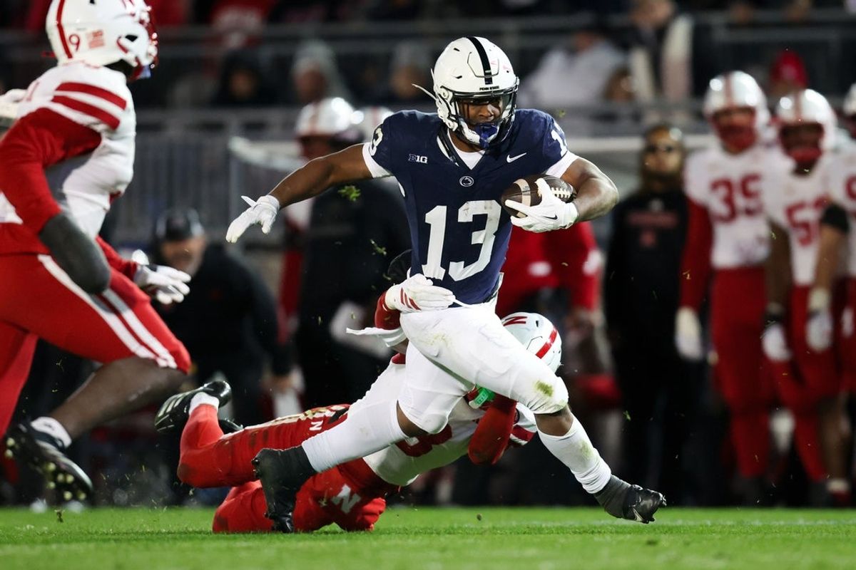 Nov 22, 2025; University Park, Pennsylvania, USA; Penn State Nittany Lions running back Kaytron Allen (13) runs with the ball while trying to avoid a tackle from Nebraska Cornhuskers defensive back DeShon Singleton (8) during the second quarter at Beaver Stadium. Mandatory Credit: Matthew O'Haren-Imagn Images