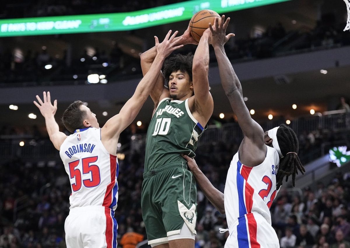 Nov 22, 2025; Milwaukee, Wisconsin, USA; Milwaukee Bucks center Jericho Sims (00) looks for an outlet pass against Detroit Pistons forward Duncan Robinson (55) and forward/center Isaiah Stewart (28) in the first half at Fiserv Forum. Mandatory Credit: Michael McLoone-Imagn Images