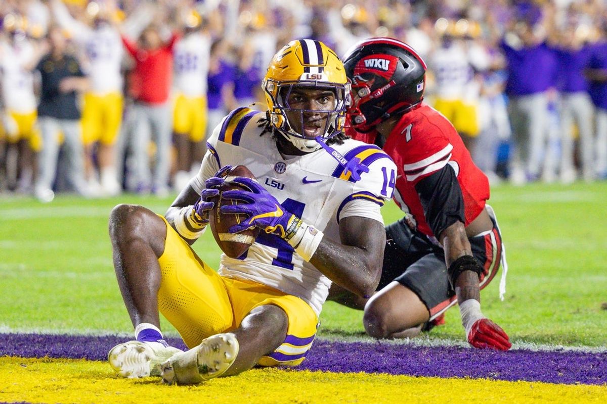 Nov 22, 2025; Baton Rouge, Louisiana, USA;  LSU Tigers tight end Trey'Dez Green (14) is tackled in the end zone for a touchdown by Western Kentucky Hilltoppers defensive back Jaylen Lewis (7) during the first half at Tiger Stadium. Mandatory Credit: Stephen Lew-Imagn Images
