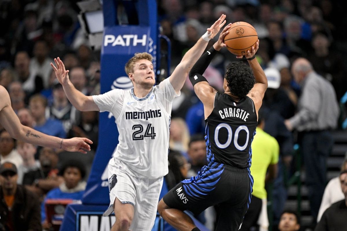 Nov 22, 2025; Dallas, Texas, USA; Dallas Mavericks guard Max Christie (00) looks to shoot the ball over Memphis Grizzlies guard Cam Spencer (24) during the second half at the American Airlines Center. Mandatory Credit: Jerome Miron-Imagn Images