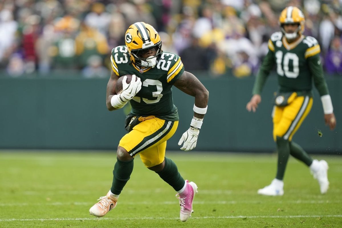 Nov 23, 2025; Green Bay, Wisconsin, USA; Green Bay Packers running back Emanuel Wilson (23) carries the ball against the Minnesota Vikings during the first half at Lambeau Field. Mandatory Credit: Kayla Wolf-Imagn Images