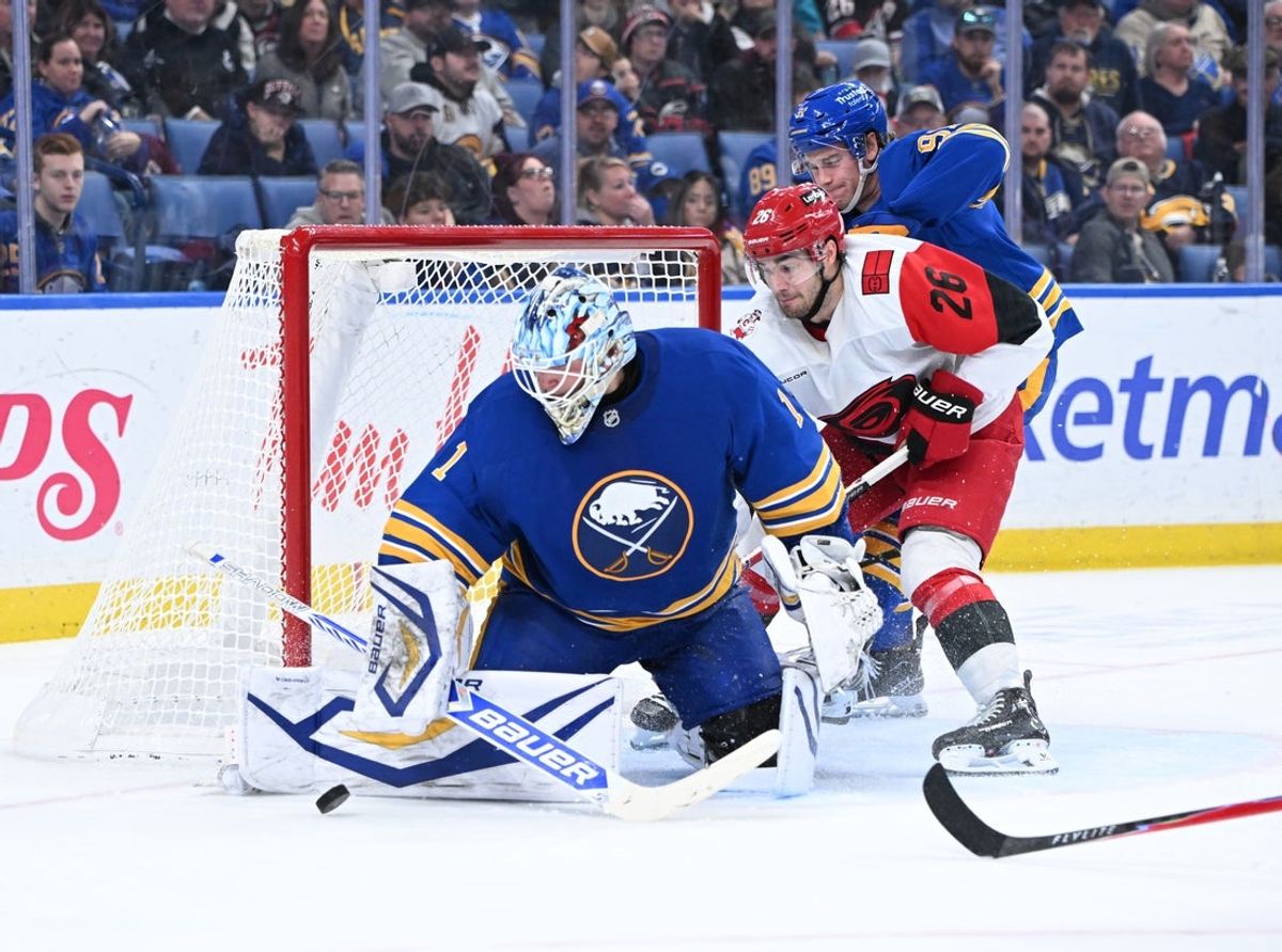 Nov 23, 2025; Buffalo, New York, USA; Buffalo Sabres goaltender Ukko-Pekka Luukkonen (1) deflects a shot with Carolina Hurricanes defenseman Sean Walker (26) near the net in the third period at KeyBank Center. Mandatory Credit: Mark Konezny-Imagn Images