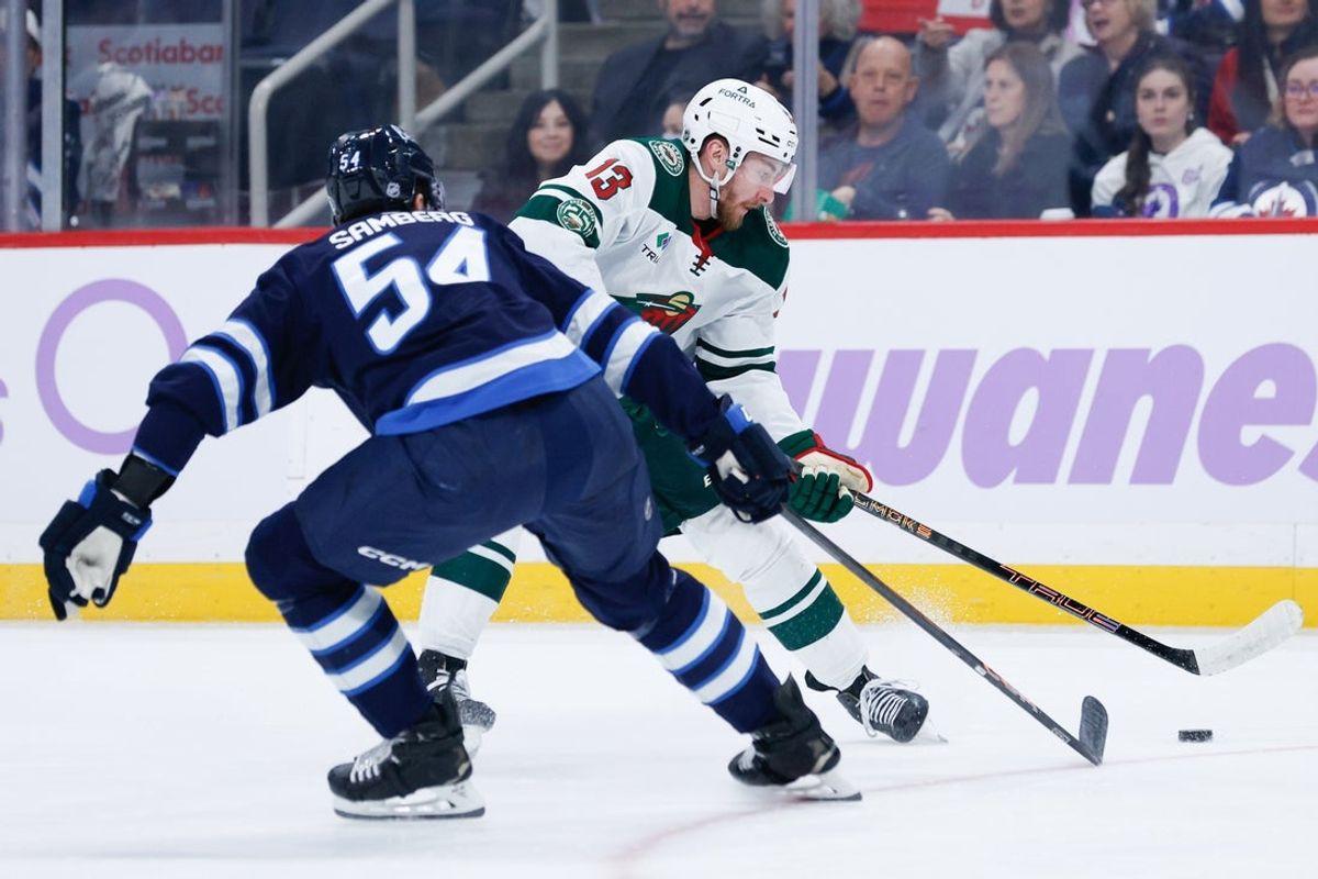 Nov 23, 2025; Winnipeg, Manitoba, CAN;  Minnesota Wild forward Yakov Trenin (13) tries to skate around Winnipeg Jets defenseman Dylan Samberg (54) during the first period at Canada Life Centre. Mandatory Credit: Terrence Lee-Imagn Images