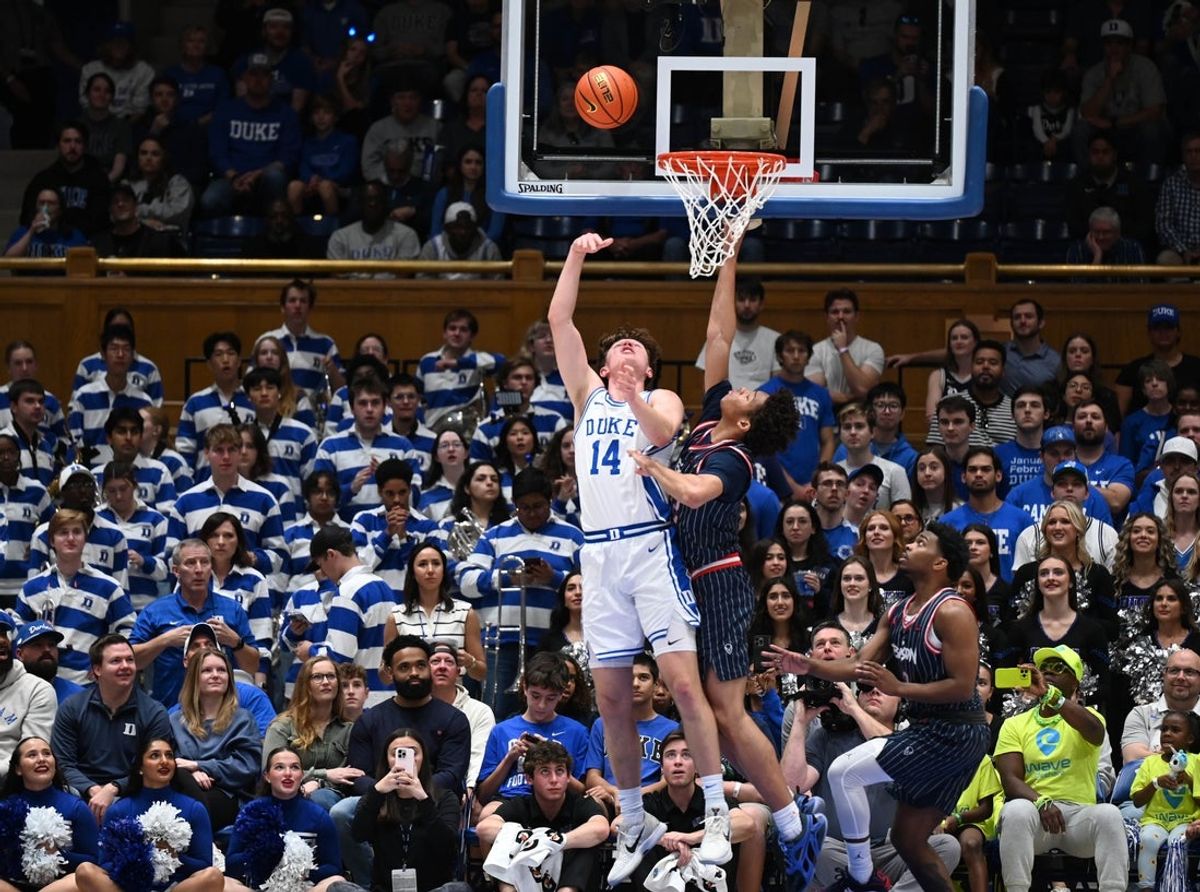 Nov 23, 2025; Durham, North Carolina, USA; Duke Blue Devils forward Nikolas Khamenia (14) lays the ball up in front of Howard Bison forward Travelle Bryson (32) during the first half at Cameron Indoor Stadium. Mandatory Credit: Rob Kinnan-Imagn Images