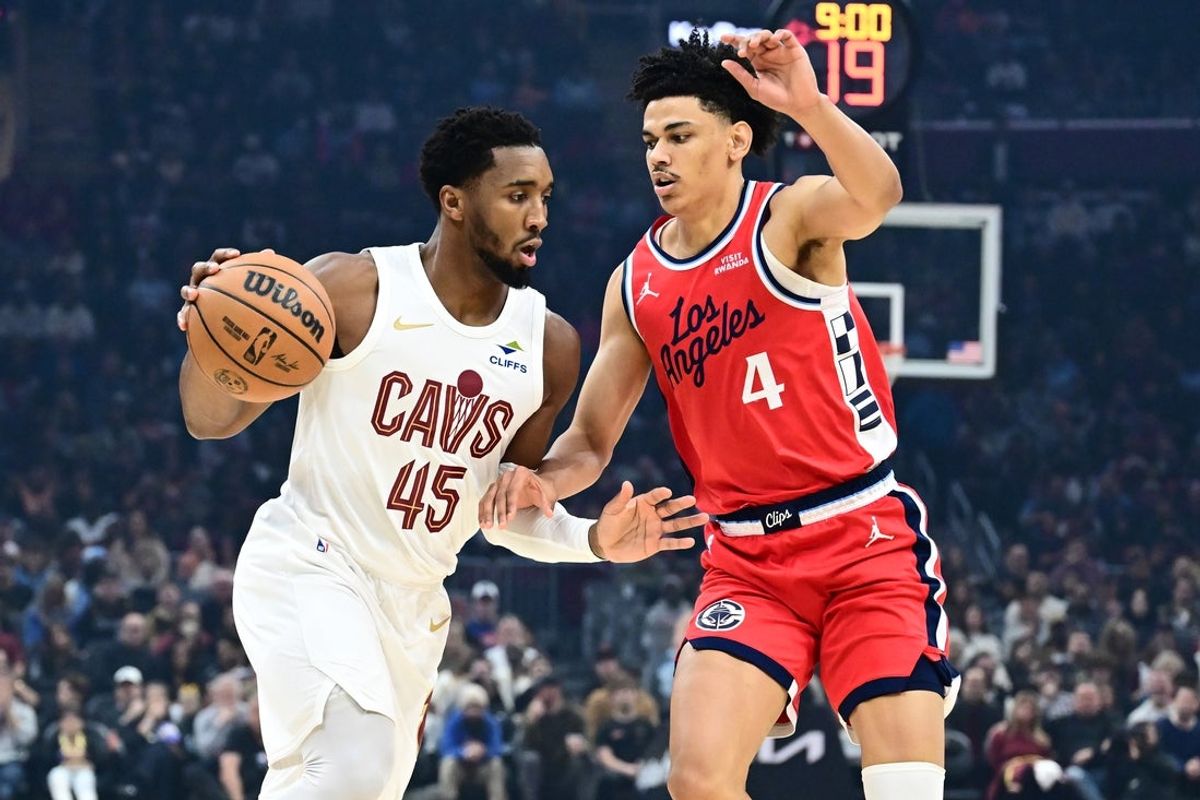 Nov 23, 2025; Cleveland, Ohio, USA; Cleveland Cavaliers guard Donovan Mitchell (45) drives to the basket against Los Angeles Clippers guard Kobe Sanders (4) during the first quarter at Rocket Arena. Mandatory Credit: Ken Blaze-Imagn Images