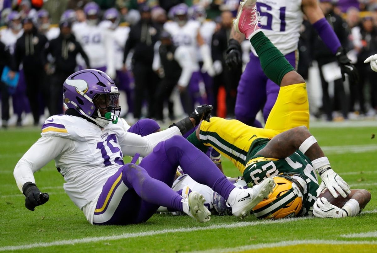 Green Bay Packers running back Emanuel Wilson (23) scores a touchdown against Minnesota Vikings linebacker Dallas Turner (15) in the third quarter during their football game Sunday, November 23, 2025, at Lambeau Field in Green Bay, Wisconsin.