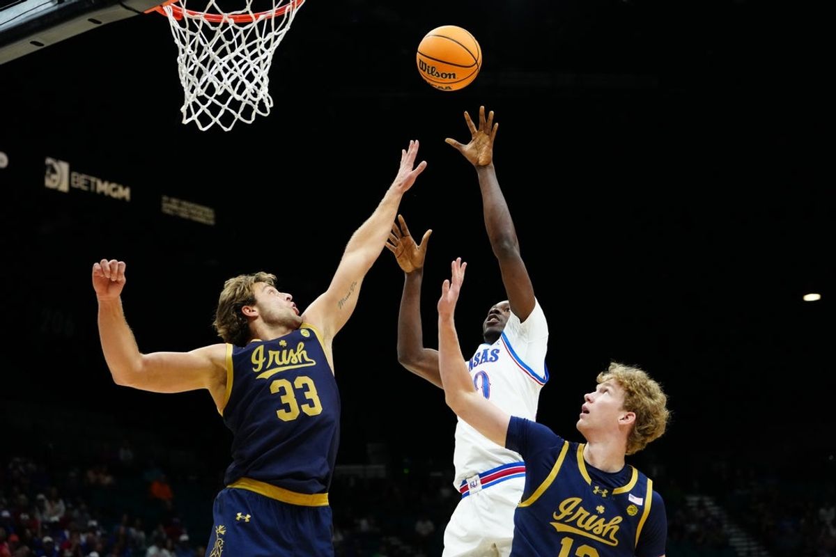 Nov 24, 2025; Las Vegas, Nevada, USA; Kansas Jayhawks forward Flory Bidunga (40) goes up for the shot as Notre Dame Fighting Irish forward Carson Towt (33) defends during the first half in a 2025 Players Era Festival group play game at MGM Grand Garden Arena. Mandatory Credit: Stephen R. Sylvanie-Imagn Images