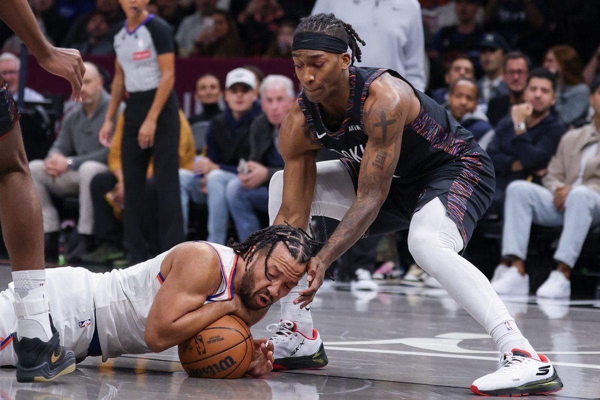 Nov 24, 2025; Brooklyn, New York, USA; New York Knicks guard Jalen Brunson (11) dives for the ball in front of Brooklyn Nets guard Terance Mann (14) during the first quarter at Barclays Center. Mandatory Credit: Vincent Carchietta-Imagn Images
