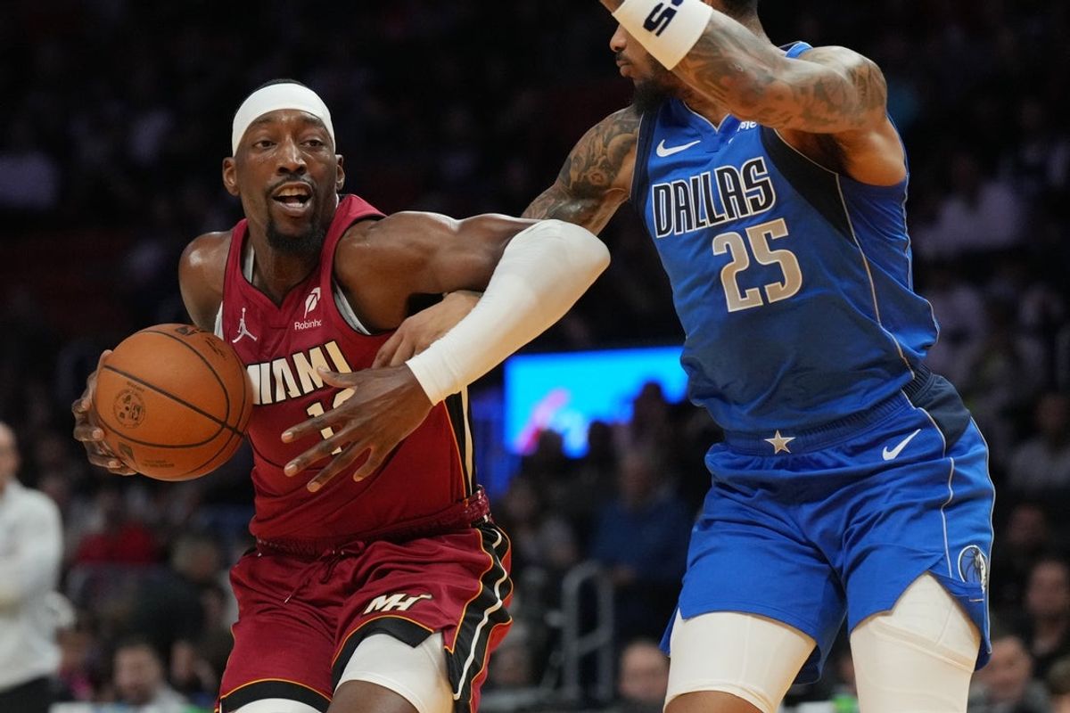 Nov 24, 2025; Miami, Florida, USA; Miami Heat center Bam Adebayo (13) drives to the basket as Dallas Mavericks forward P.J. Washington (25) defends in the first half at Kaseya Center. Mandatory Credit: Jim Rassol-Imagn Images