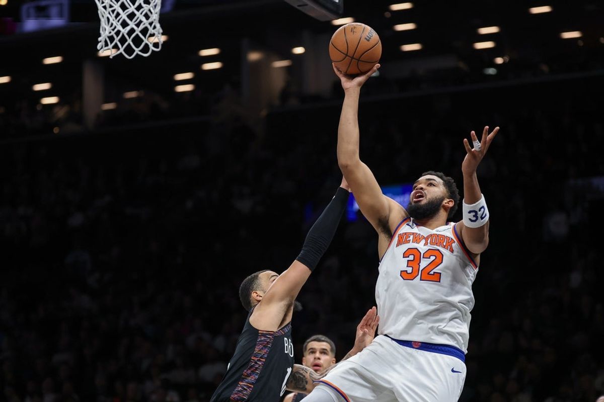 Nov 24, 2025; Brooklyn, New York, USA; New York Knicks center Karl-Anthony Towns (32) shoots the ball as Brooklyn Nets guard Tyrese Martin (13) defends during the first half at Barclays Center. Mandatory Credit: Vincent Carchietta-Imagn Images