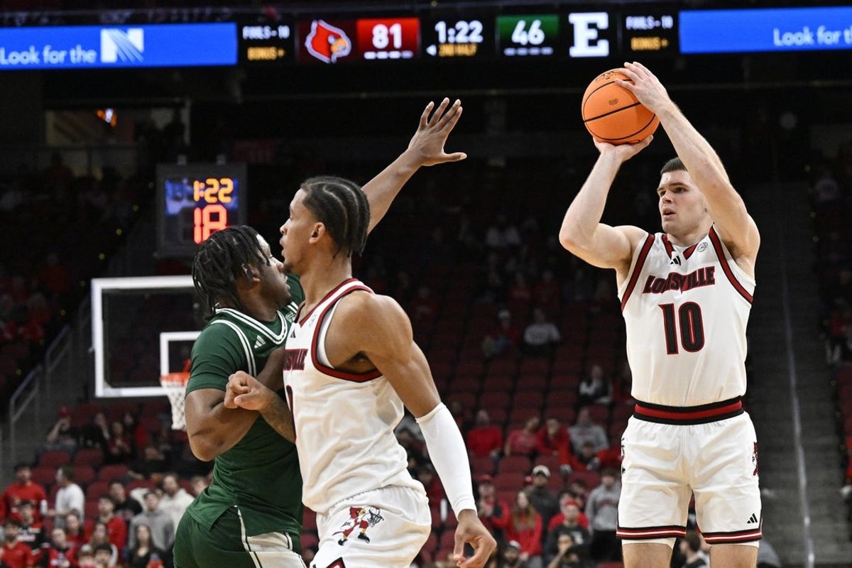 Nov 24, 2025; Louisville, Kentucky, USA; Louisville Cardinals guard Isaac McKneely (10) shoots a three point shot against Eastern Michigan Eagles guard Gregory Lawson (0) during the second half at KFC Yum! Center. Louisville defeated Eastern Michigan 87-46. Mandatory Credit: Jamie Rhodes-Imagn Images