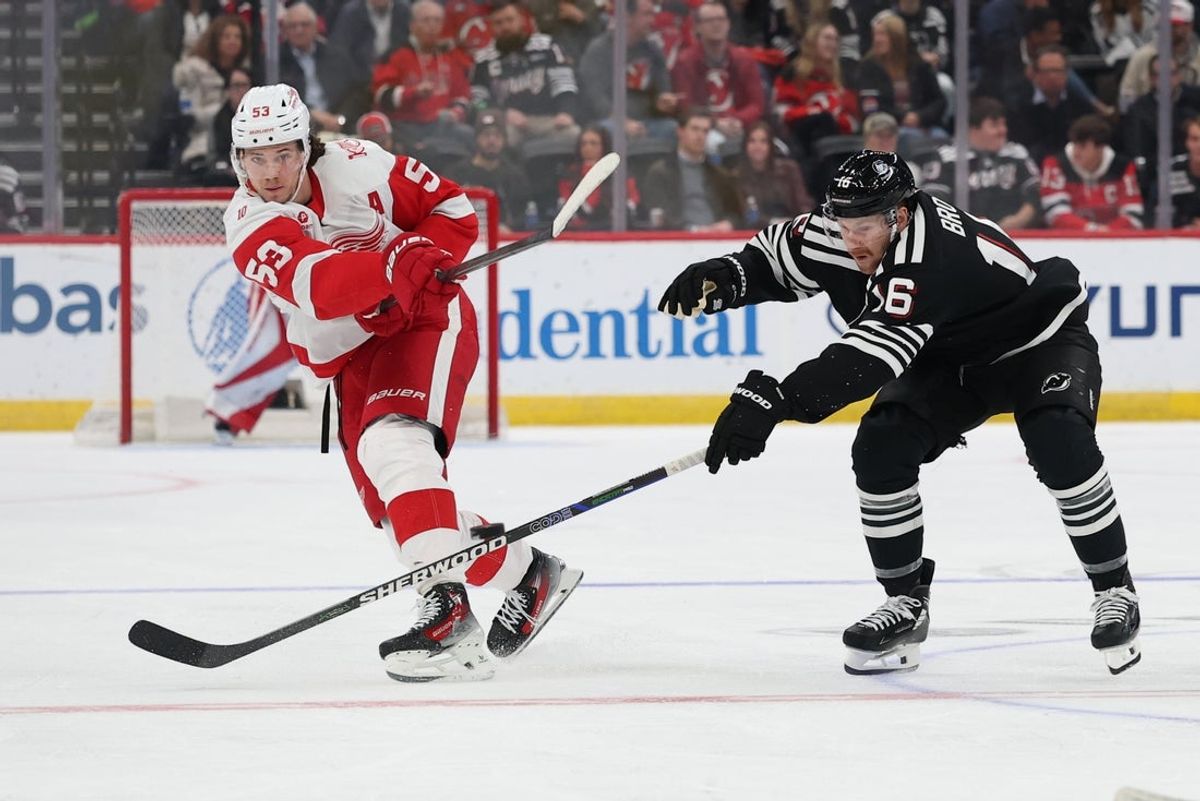Nov 24, 2025; Newark, New Jersey, USA; Detroit Red Wings defenseman Moritz Seider (53) shoots the puck as New Jersey Devils right wing Connor Brown (16) defends during the third period at Prudential Center. Mandatory Credit: Ed Mulholland-Imagn Images