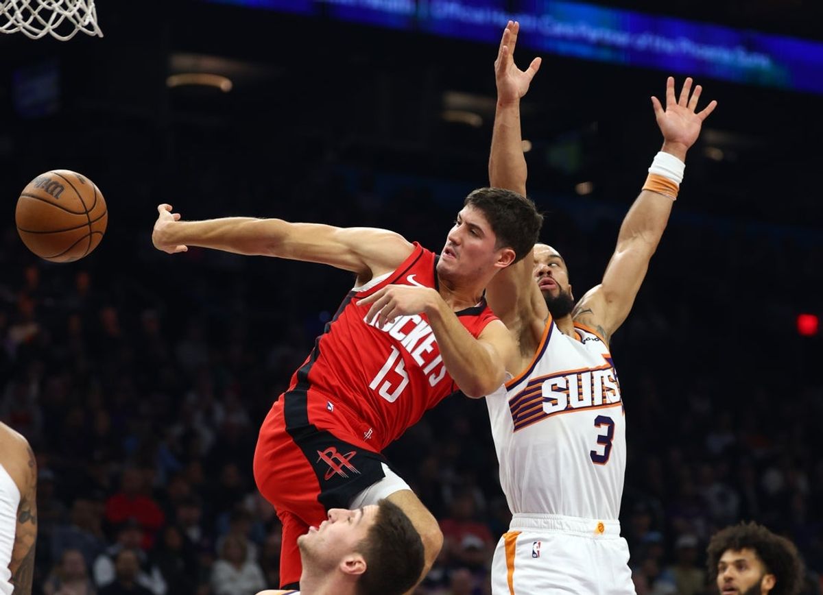 Nov 24, 2025; Phoenix, Arizona, USA; Houston Rockets guard Reed Sheppard (15) passes the ball against Phoenix Suns forward Dillon Brooks (3) in the first half at Mortgage Matchup Center. Mandatory Credit: Mark J. Rebilas-Imagn Images