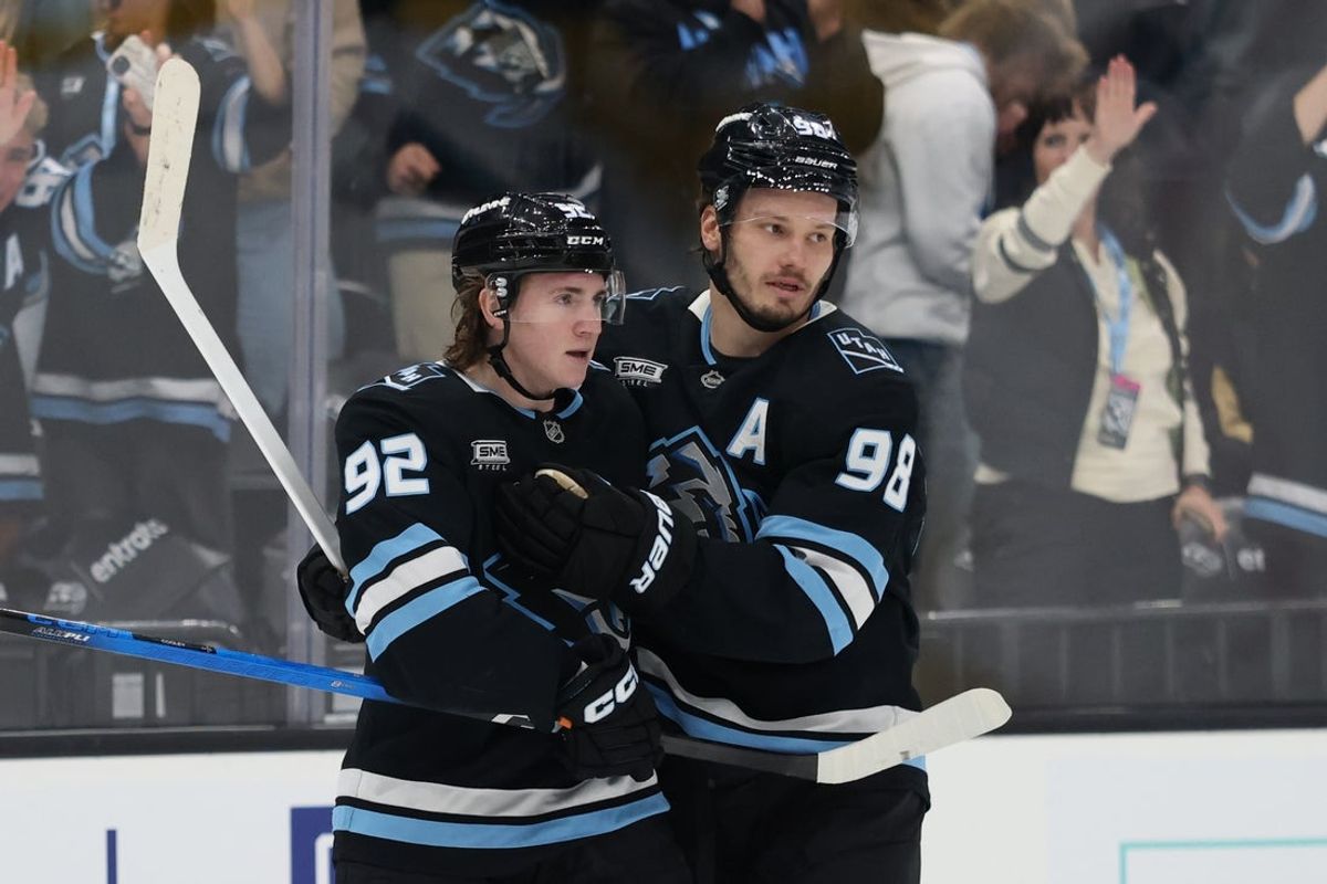 Nov 24, 2025; Salt Lake City, Utah, USA; Utah Mammoth center Logan Cooley (92) scores a goal and celebrates with defenseman Mikhail Sergachev (98) during the third period of the game against the Vegas Golden Knights at Delta Center. Mandatory Credit: Rob Gray-Imagn Images