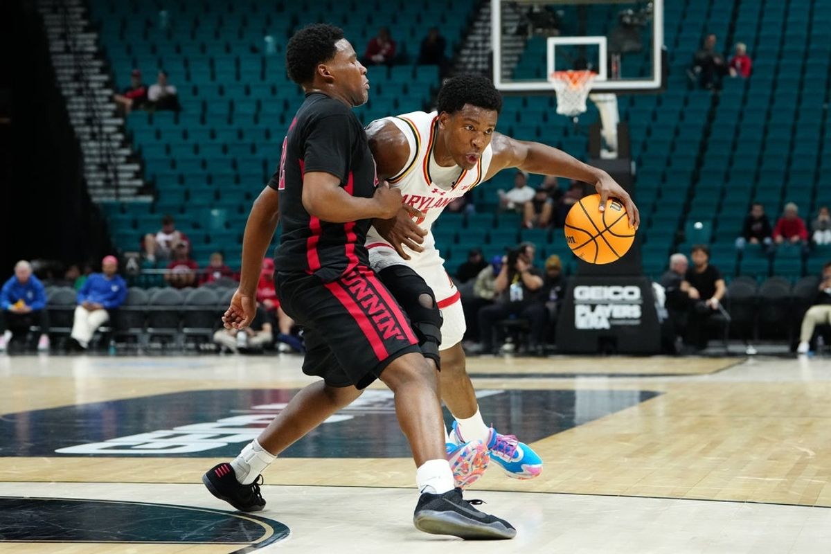 Nov 24, 2025; Las Vegas, Nevada, USA; Maryland Terrapins forward Pharrel Payne (21) controls the ball against UNLV Rebels guard Issac Williamson (12) during the first half in a 2025 Players Era Festival group play game at MGM Grand Garden Arena. Mandatory Credit: Stephen R. Sylvanie-Imagn Images