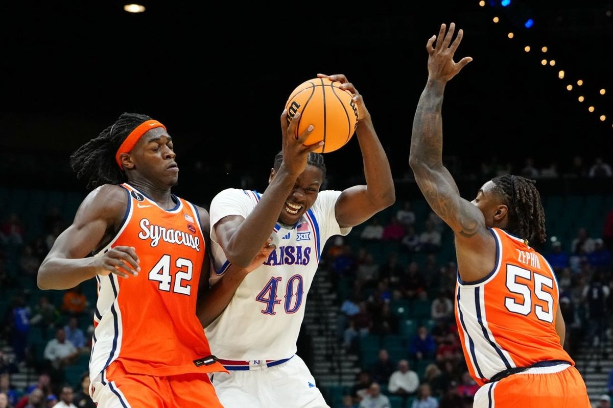 Nov 25, 2025; Las Vegas, Nevada, USA; Kansas Jayhawks forward Flory Bidunga (40) drives to the basket defended by Syracuse Orange forward William Kyle III (42) and guard Bryce Zephir (55) during the first half in a 2025 Players Era Festival group play game at MGM Grand Garden Arena. Mandatory Credit: Stephen R. Sylvanie-Imagn Images