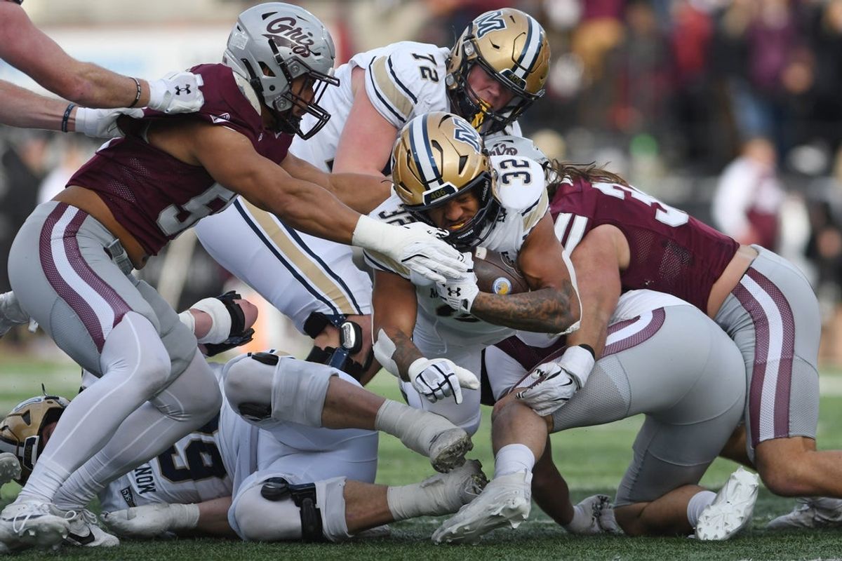 Nov 22, 2025; Missoula, MT, USA; Montana State Bobcats running back Julius Davis (32) is tackled by Montana Grizzlies linebacker Solomon Tuliaupupu (58) and linebacker Peyton Wing (32) during the first half at Washington-Grizzly Stadium. Mandatory Credit: Michael Thomas Shroyer-Imagn Images