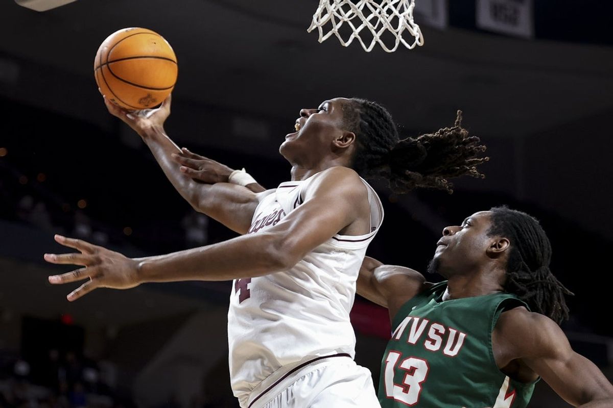 Nov 25, 2025; College Station, Texas, USA; Texas A&M Aggies forward Jamie Vinson (4) is folded by Mississippi Valley State Delta Devils forward Tyrone Iroghama (13) during the first half at Reed Arena. Mandatory Credit: Maria Lysaker-Imagn Images