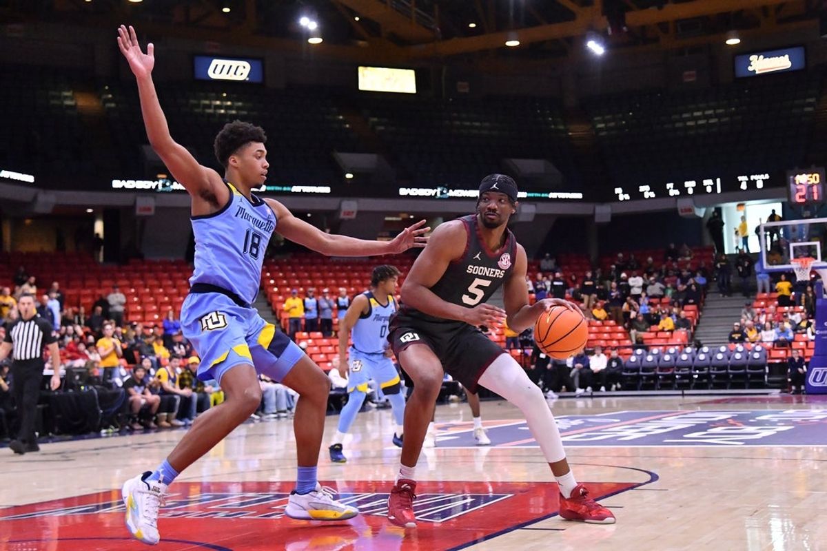 Nov 28, 2025; Chicago, Illinois, USA; Oklahoma Sooners forward Mohamed Wague (5) controls the ball against Marquette Golden Eagles forward Caedin Hamilton (18) during the first half at Credit Union 1 Arena. Mandatory Credit: Patrick Gorski-Imagn Images