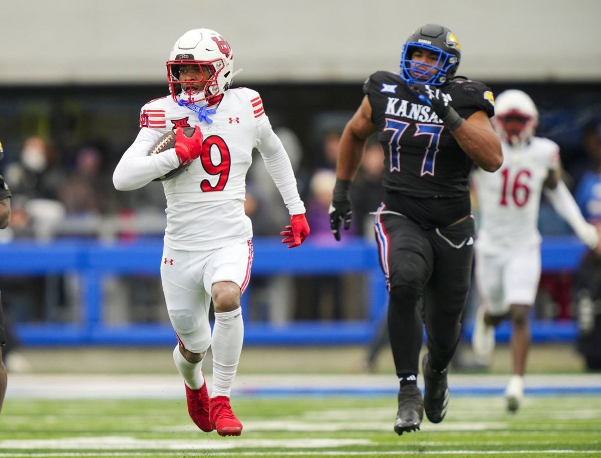 Nov 28, 2025; Lawrence, Kansas, USA; Utah Utes cornerback Elijah Davis (9) returns an interception for a touchdown during the second half against the Kansas Jayhawks at David Booth Kansas Memorial Stadium. Mandatory Credit: Jay Biggerstaff-Imagn Images