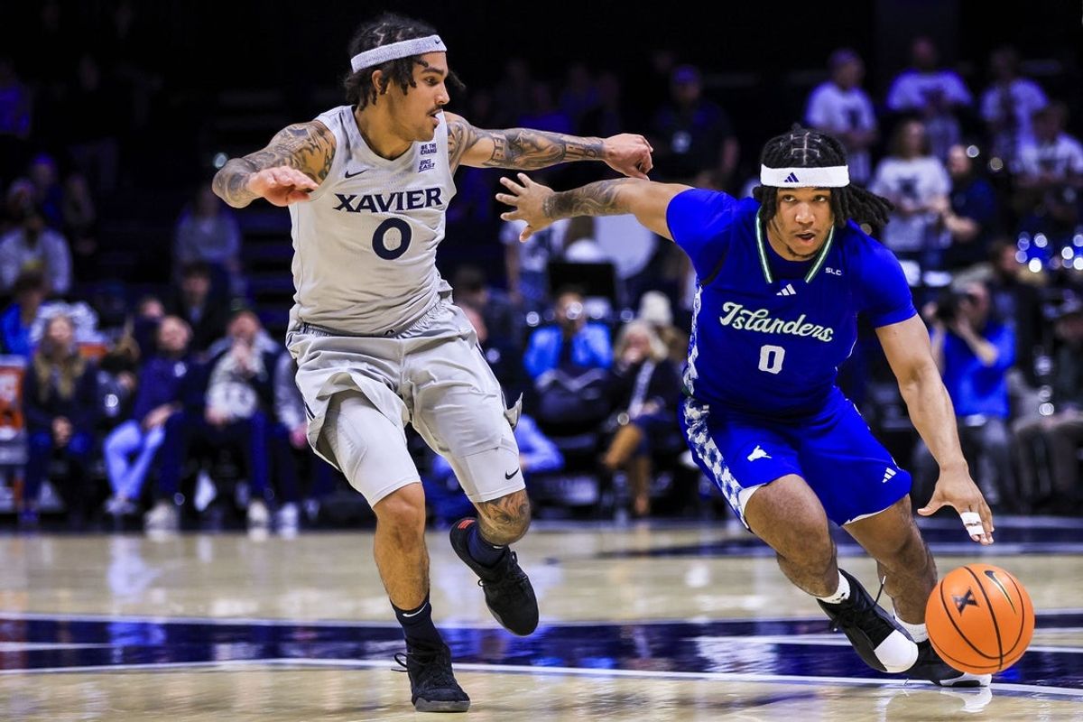 Nov 28, 2025; Cincinnati, Ohio, USA; Texas A&M-Corpus Christi Islanders guard D'Avian Houston (0) dribbles against Xavier Musketeers guard Roddie Anderson III (0) in the first half at Cintas Center. Mandatory Credit: Katie Stratman-Imagn Images