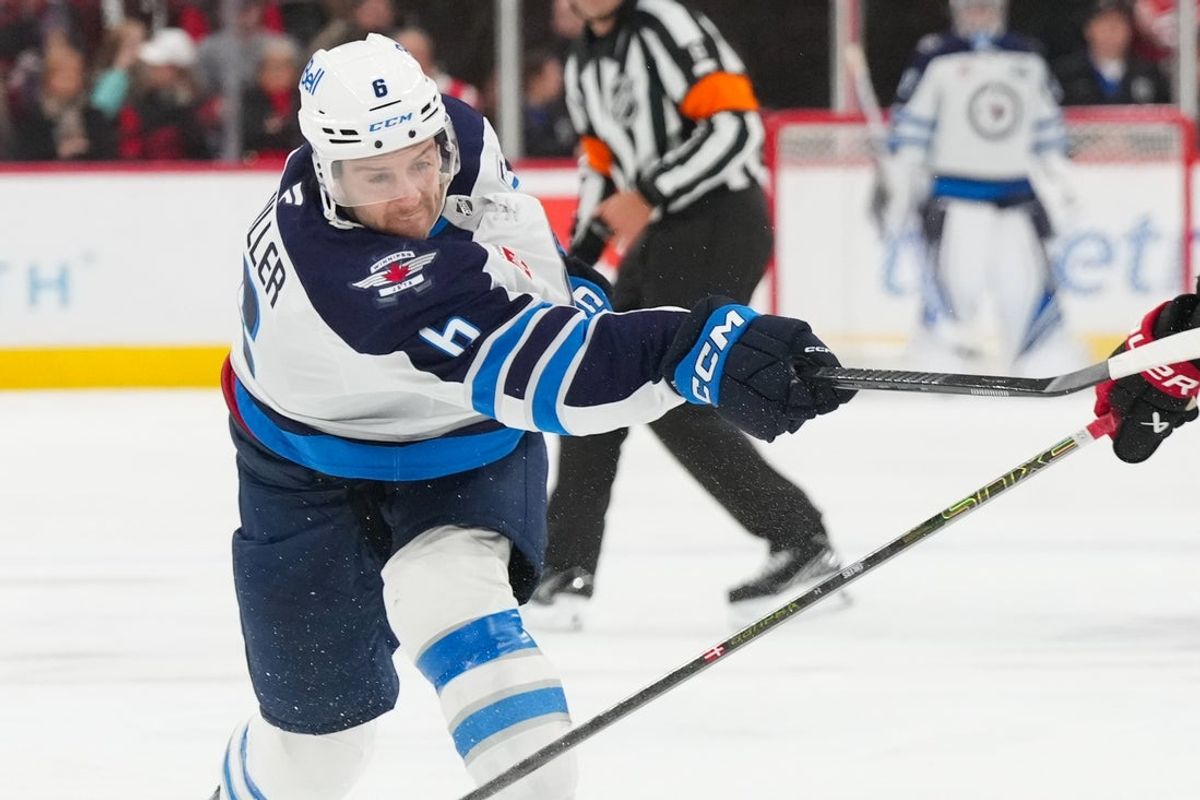 Nov 28, 2025; Raleigh, North Carolina, USA;  Winnipeg Jets defenseman Colin Miller (6) takes a shot against the Carolina Hurricanes during the second period at Lenovo Center. Mandatory Credit: James Guillory-Imagn Images