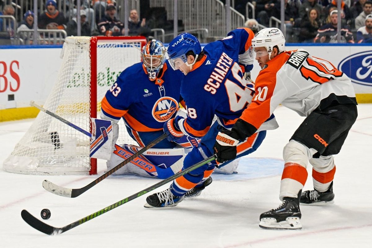 Nov 28, 2025; Elmont, New York, USA; New York Islanders defenseman Matthew Schaefer (48) and Philadelphia Flyers right wing Bobby Brink (10) battle for the puck during the third period at UBS Arena. Mandatory Credit: Dennis Schneidler-Imagn Images