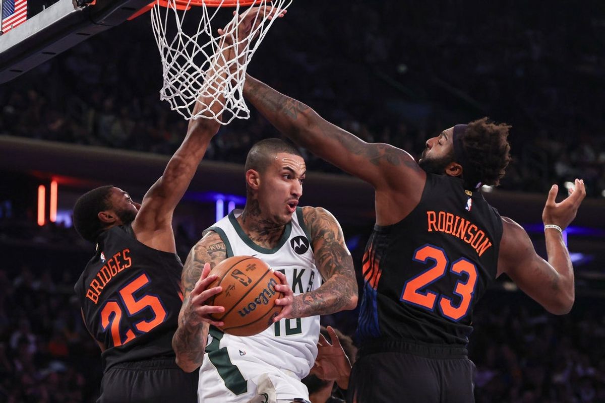 Nov 28, 2025; New York, New York, USA; Milwaukee Bucks forward Kyle Kuzma (18) passes the ball as New York Knicks guard Mikal Bridges (25) and center Mitchell Robinson (23) defend during the first half at Madison Square Garden. Mandatory Credit: Vincent Carchietta-Imagn Images