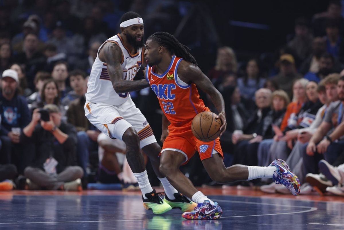 Nov 28, 2025; Oklahoma City, Oklahoma, USA; Oklahoma City Thunder guard Cason Wallace (22) moves the ball past Phoenix Suns forward Royce O'Neale (00) during the first quarter at Paycom Center. Mandatory Credit: Alonzo Adams-Imagn Images