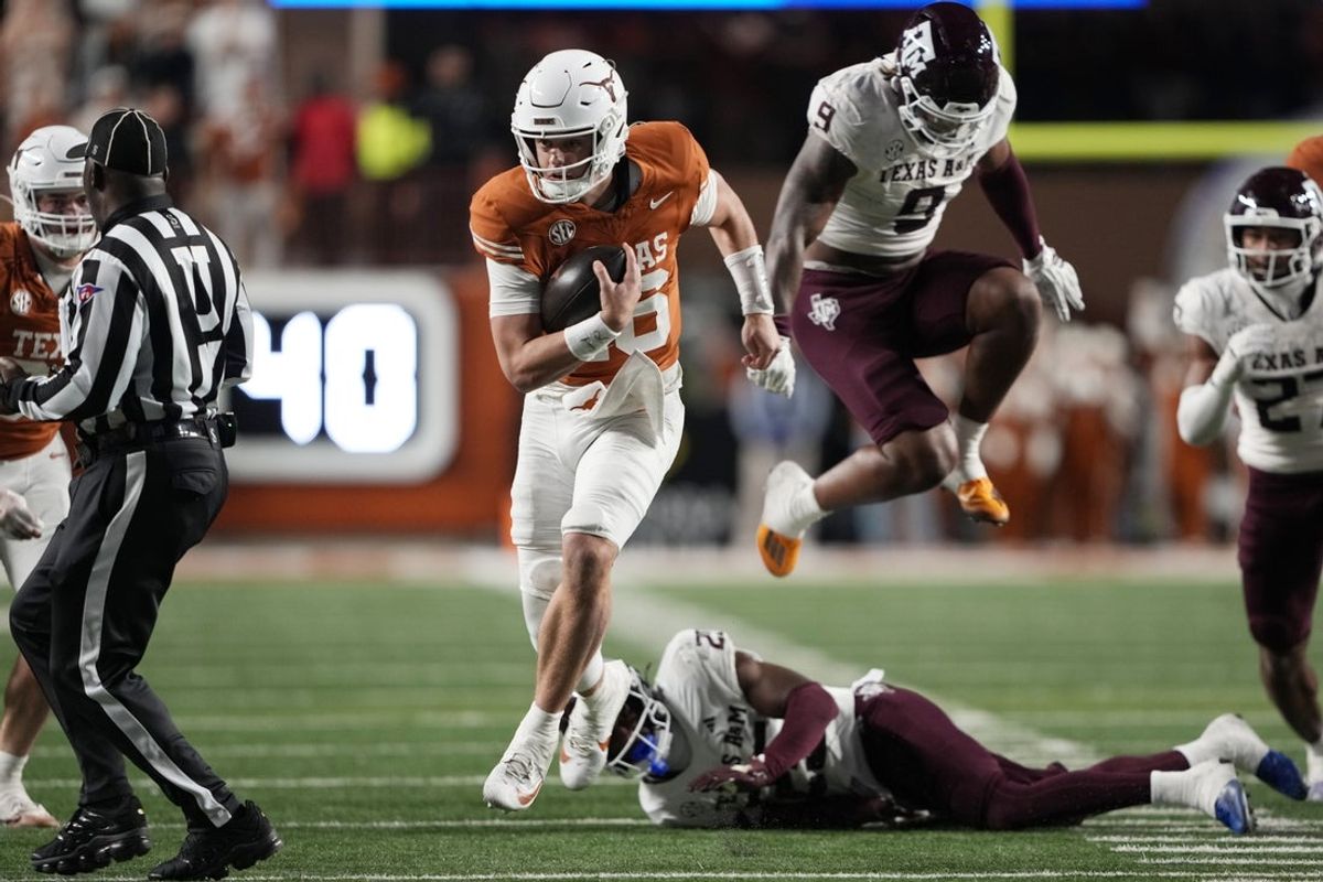 Nov 28, 2025; Austin, Texas, USA; Texas Longhorns quarterback Arch Manning keeps the ball and runs for a touchdown during the second half against the Texas A&M Aggies at Darrell K Royal-Texas Memorial Stadium. Mandatory Credit: Scott Wachter-Imagn Images