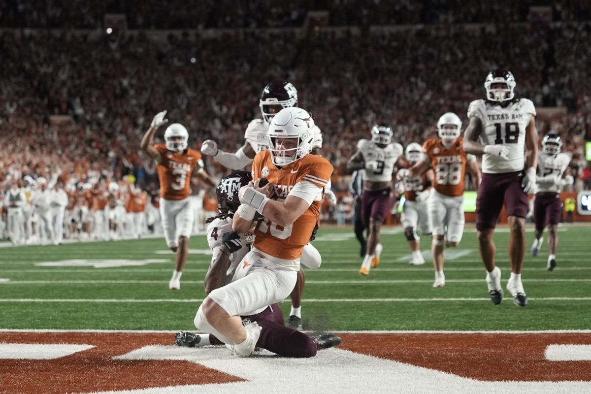 Nov 28, 2025; Austin, Texas, USA; Texas Longhorns quarterback Arch Manning keeps the ball and runs for a touchdown during the second half against the Texas A&M Aggies at Darrell K Royal-Texas Memorial Stadium. Mandatory Credit: Scott Wachter-Imagn Images