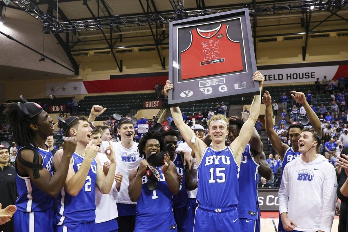 Nov 28, 2025; Kissimmee, FL, USA; Brigham Young University Cougars guard Richie Saunders (15) is given the tournament MVP award after beating the Dayton Flyers during the ESPN Events Invitational at State Farm Field House. Mandatory Credit: Nathan Ray Seebeck-Imagn Images