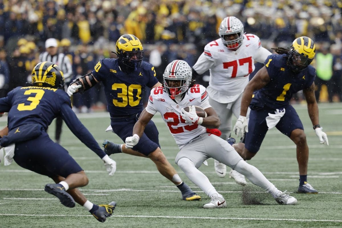 Nov 29, 2025; Ann Arbor, Michigan, USA; Ohio State Buckeyes running back Bo Jackson (25) runs the ball pressured by Michigan Wolverines linebacker Jimmy Rolder (30) and defensive back Jaden Mangham (3) in the first half at Michigan Stadium. Mandatory Credit: Rick Osentoski-Imagn Images