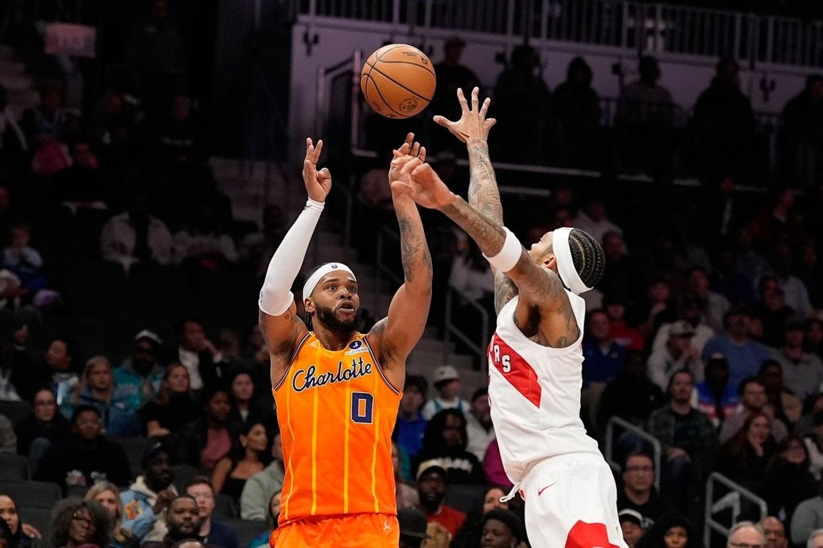 Nov 29, 2025; Charlotte, North Carolina, USA; Charlotte Hornets forward Miles Bridges (0) shoots the ball against Toronto Raptors forward Brandon Ingram (3) during the second quarter at Spectrum Center. Mandatory Credit: Jim Dedmon-Imagn Images