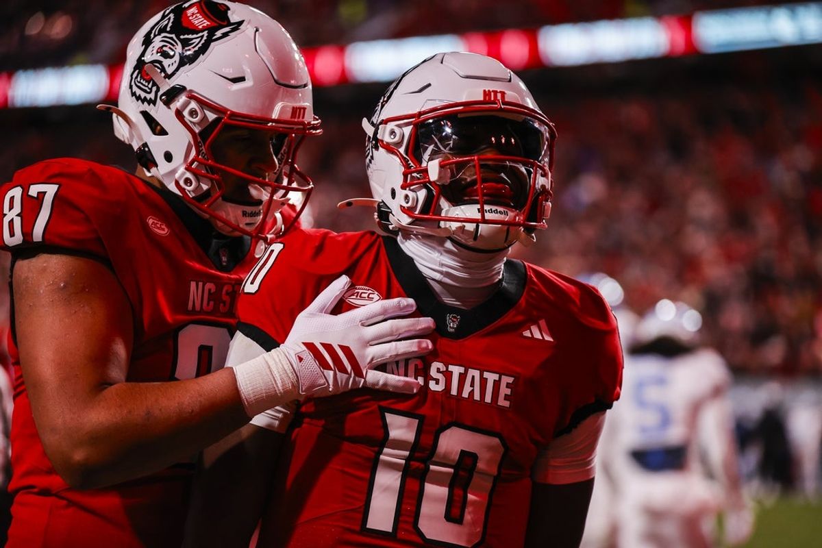 Nov 29, 2025; Raleigh, North Carolina, USA;  NC State Wolfpack quarterback Will Wilson (10) makes a touchdown and celebrates with tight end Dante Daniels (87) during the first half of the game against North Carolina Tar Heels at Carter-Finley Stadium.  Mandatory Credit: Jaylynn Nash-Imagn Images