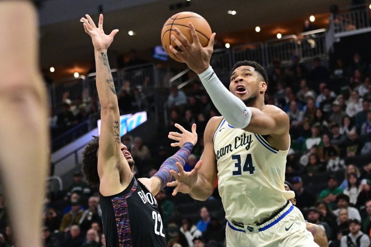 Nov 29, 2025; Milwaukee, Wisconsin, USA; Milwaukee Bucks forward Giannis Antetokounmpo (34) makes a layup against Brooklyn Nets forward Jalen Wilson (22) in the second quarter at Fiserv Forum. Mandatory Credit: Benny Sieu-Imagn Images