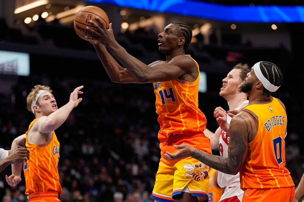 Nov 29, 2025; Charlotte, North Carolina, USA; Charlotte Hornets forward Moussa Diabate (14) rebounds the ball against Toronto Raptors center Jakob Poeltl (19) during the second half at Spectrum Center. Mandatory Credit: Jim Dedmon-Imagn Images