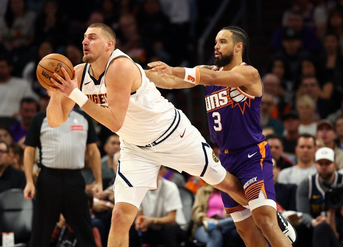 Nov 29, 2025; Phoenix, Arizona, USA; Denver Nuggets center Nikola Jokic (15) is fouled by Phoenix Suns forward Dillon Brooks (3) in the first half at the Mortgage Matchup Center. Mandatory Credit: Mark J. Rebilas-Imagn Images