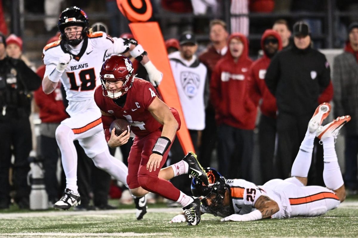 Nov 29, 2025; Pullman, Washington, USA; Washington State Cougars quarterback Zevi Eckhaus (4) is tripped up by Oregon State Beavers linebacker Nikko Taylor (25) in the second half at Gesa Field at Martin Stadium. Washington State Cougars won 32-8. Mandatory Credit: James Snook-Imagn Images