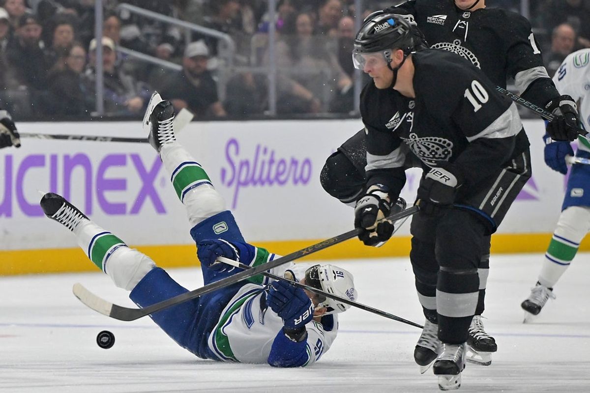 Nov 29, 2025; Los Angeles, California, USA;  Los Angeles Kings right wing Corey Perry (10) takes control of the puck as he gets past Vancouver Canucks left wing Evander Kane (91) during the first period at Crypto.com Arena. Mandatory Credit: Jayne Kamin-Oncea-Imagn Images