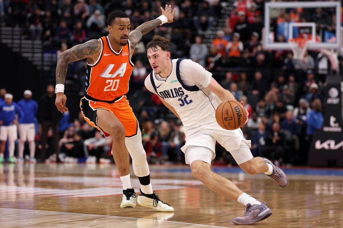 Nov 29, 2025; Inglewood, California, USA;  Dallas Mavericks forward Cooper Flagg (32) dribbles the ball against Los Angeles Clippers forward John Collins (20) during the fourth quarter at Intuit Dome. Mandatory Credit: Kiyoshi Mio-Imagn Images