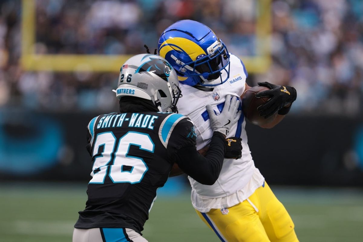 Nov 30, 2025; Charlotte, North Carolina, USA; Los Angeles Rams wide receiver Davante Adams (17) runs after making a catch as Carolina Panthers cornerback Chau Smith-Wade (26) defends during the first quarter at Bank of America Stadium. Mandatory Credit: Scott Kinser-Imagn Images