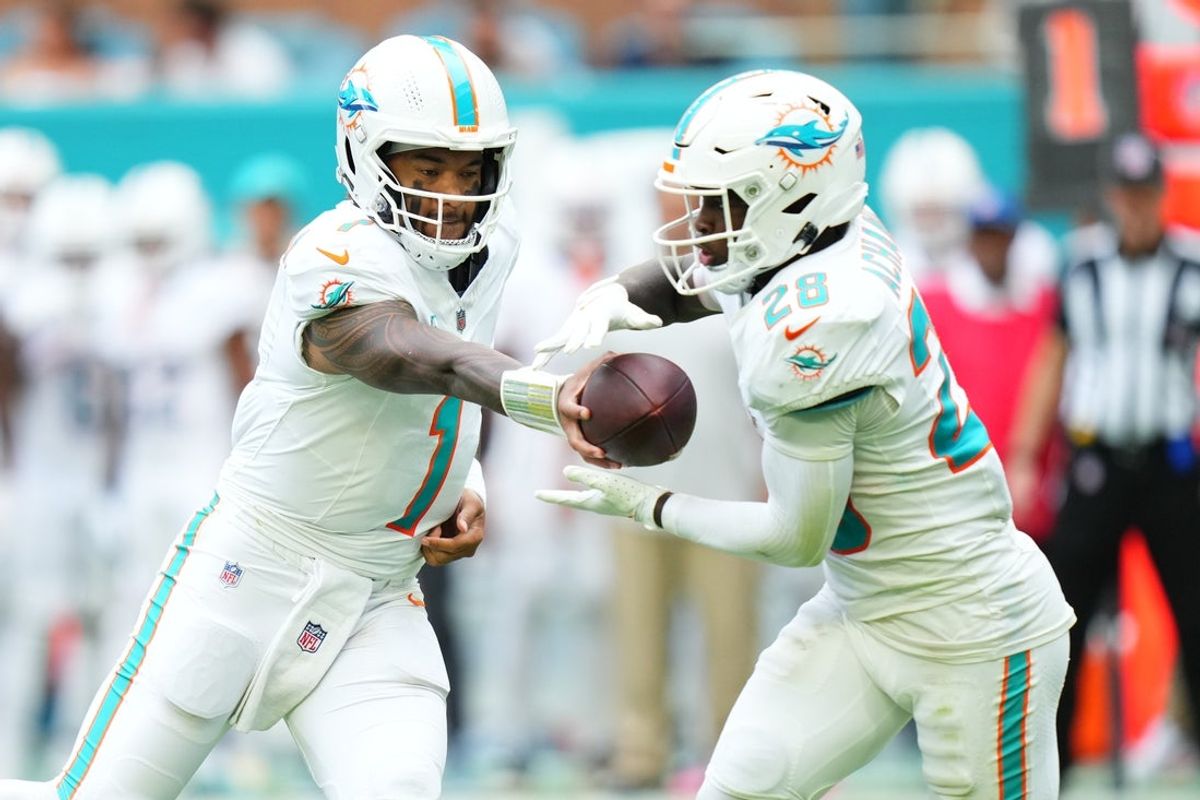 Nov 30, 2025; Miami Gardens, Florida, USA; Miami Dolphins quarterback Tua Tagovailoa (1) hands off to running back De'Von Achane (28) against the New Orleans Saints during the second half at Hard Rock Stadium. Mandatory Credit: Rich Storry-Imagn Images