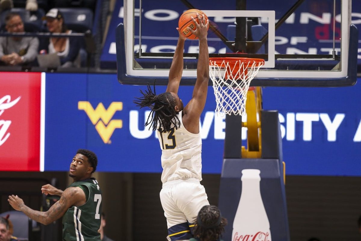 Nov 30, 2025; Morgantown, West Virginia, USA; West Virginia Mountaineers guard Chance Moore (13) dunks the ball during the first half against the Mercyhurst Lakers at Hope Coliseum. Mandatory Credit: Ben Queen-Imagn Images